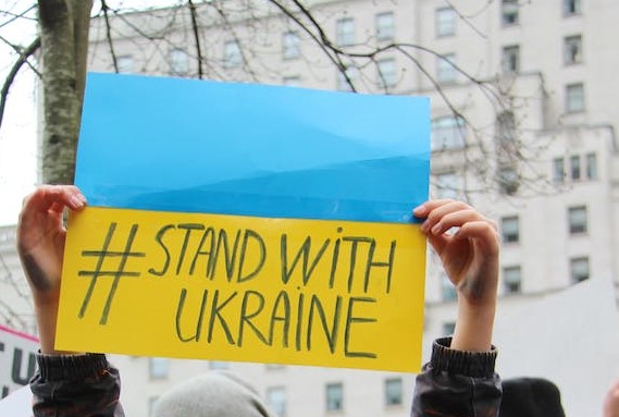 Ukrainische Flagge mit aufgeschriebenem Text: #stand with ukraine